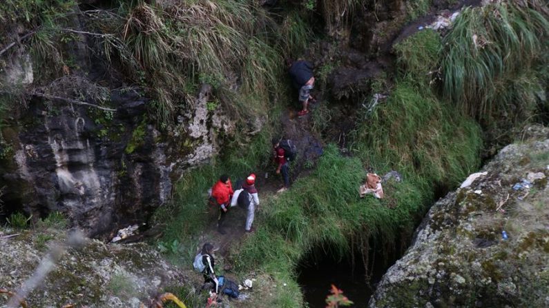 Fotografía del 13 de mayo de 2020 que muestra a migrantes venezolanos que caminan por una ladera en Colombia tras haber cruzado el río Carchi desde Ecuador, por uno de los pasos ilegales en el sector del Complejo de Rumichaca y el Brinco, a pocos metros del puente internacional. EFE/ Xavier Montalvo/ Archivo
