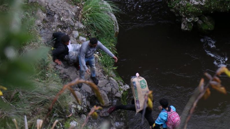 Fotografía del 13 de mayo de 2020 que muestra a migrantes venezolanos que cruzan el río Carchi, en la frontera entre Colombia y Ecuador, por uno de los pasos ilegales en el sector del Complejo de Rumichaca y el Brinco, a pocos metros del puente internacional. EFE/ Xavier Montalvo/Archivo