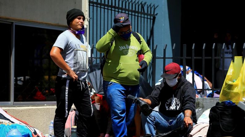 Ciudadanos venezolanos esperan para ser tomados en cuenta en los viajes de repatriación que se están realizando de Ecuador a Venezuela el 15 de mayo de 2020 afuera del Consulado de Venezuela en Quito (Ecuador). EFE/José Jácome