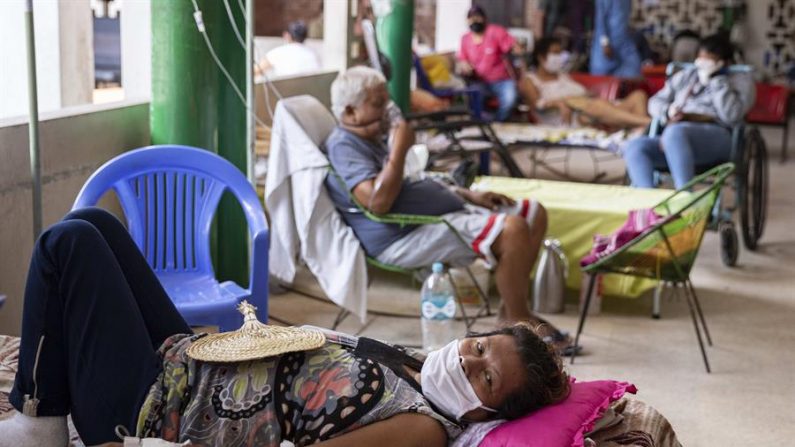 Una mujer con mascarilla descansa en una sala con pacientes de COVID-19 en el Hospital Regional de Iquitos, el 7 de mayo de 2020, en Iquitos (Perú). EFE/Ginebra Peña
