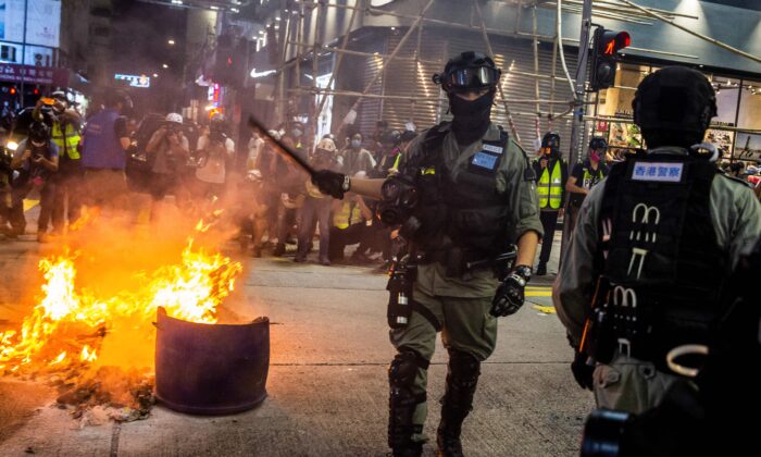 La policía despejó una calle cerca del lugar de un incendio provocado durante una protesta prodemocracia en el distrito Mong Kok de Hong Kong el 27 de mayo de 2020. (Isaac Lawrence/AFP vía Getty Images)