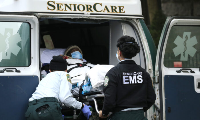 Trabajadores de los Servicios Médicos de Emergencia descargan a un paciente de su ambulancia en el Centro de Salud de Cobble Hill en el barrio de Cobble Hill del distrito de Brooklyn en Nueva York, el 18 de abril de 2020. (Justin Heiman/Getty Images)