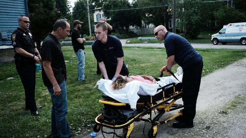 Los trabajadores médicos y la policía tratan a una mujer que ha tomado una sobredosis de heroína, el segundo caso en cuestión de minutos en Warren, Ohio, el 14 de julio de 2017. (Spencer Platt/Getty Images)