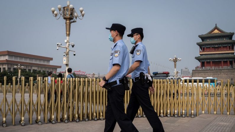 Oficiales de policía patrullan un área fuera de la Plaza Tiananmen de Beijing en el Día Mundial de la Libertad de Prensa el 3 de mayo de 2020. (Nicolas Asfouri/AFP vía Getty Images)