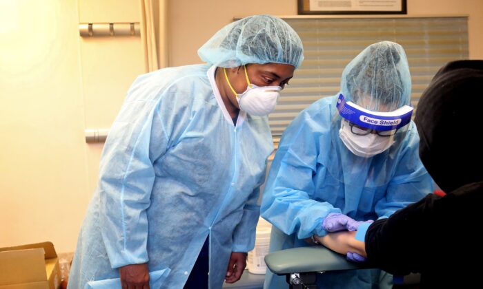 Flebotomistas extraen sangre de personas que se hacen la prueba de anticuerpos del virus del PCCh en el Centro de Salud Refuah en Spring Valley, Nueva York, el 24 de abril de 2020. (Yana Paskova / Getty Images)