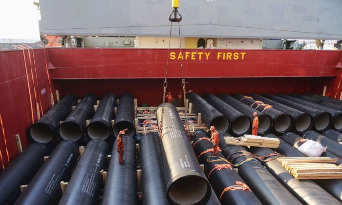 Los trabajadores están cargando tuberías que se exportarán a África en un puerto de Qingdao en la provincia oriental de Shandong de China el 1º de abril de 2019. (STR/AFP/Getty Images)