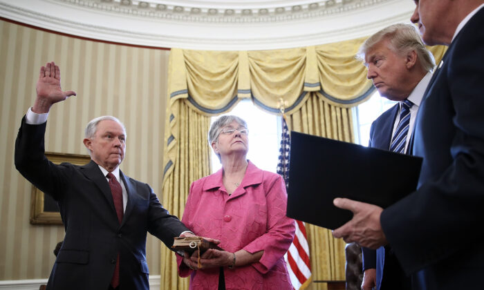 El presidente Donald Trump observa cómo Jeff Sessions, a la izquierda, es jurado como el nuevo Fiscal General por el Vicepresidente Mike Pence, a la derecha, en la Oficina Oval de la Casa Blanca, el 9 de febrero de 2017. También se muestra a la esposa de Sessions, Mary, sosteniendo la Biblia (Win McNamee/Getty Images)
 
