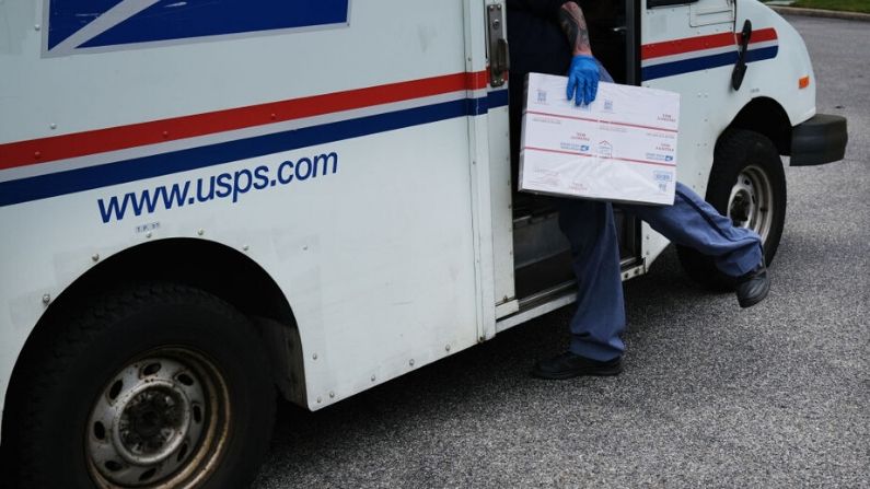 El trabajador del Servicio Postal de Estados Unidos Lou Martini sigue su ruta de reparto diaria durante la pandemia de coronavirus el 15 de abril de 2020 en Kings Park, Nueva York. (Spencer Platt/Getty Images)