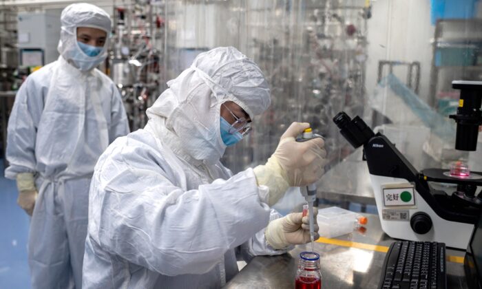 Un ingeniero toma muestras de células de riñón de mono mientras hace pruebas de una vacuna experimental para el COVID-19 dentro del laboratorio de la Sala de Cultivo de Células en las instalaciones de Sinovac Biotech en Beijing, China, el 29 de abril de 2020. (Nicolas Asfouri/AFP vía Getty Images)