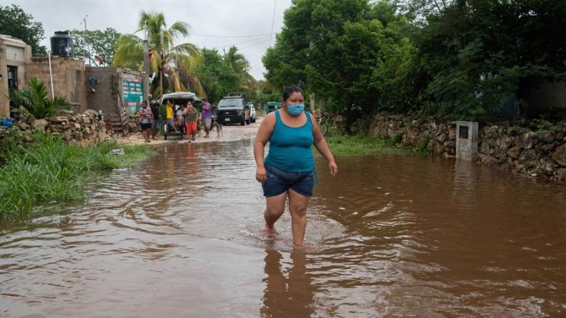 Una mujer camina por una calle inundada el 3 de junio de 2020 en la Zona Norponiente del municipio de Tecoch, en el estado de Yucatán (México). EFE/ Cuauhtémoc Moreno