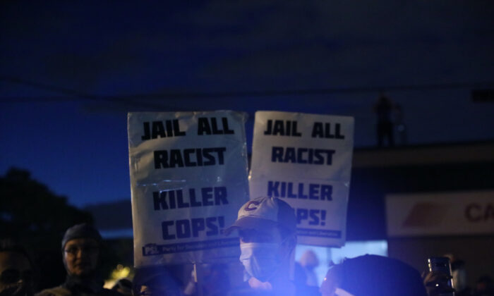 Los agitadores sostienen carteles afuera del 5to Recinto de la Policía de Minneapolis durante la cuarta noche de disturbios y violencia luego de la muerte de George Floyd, en Minneapolis, Minnesota, el 29 de mayo de 2020. (Charlotte Cuthbertson/The Epoch Times)
