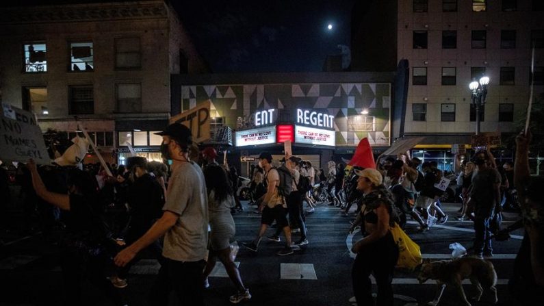 Manifestantes caminan frente al el teatro Regent leyendo 'No puede haber amor sin justicia', durante una gran manifestación con miles de personas, en Los Ángeles, California, EE. UU. EFE/EPA/ETIENNE LAURENT