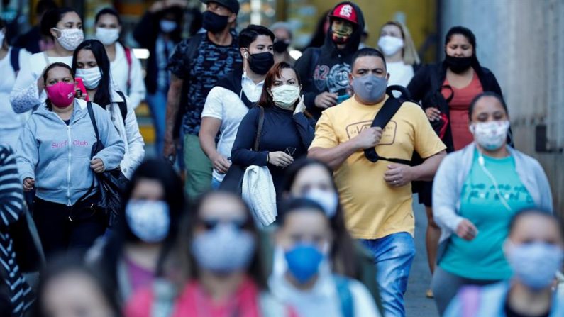 Personas con mascarilla caminan por una calle el 14 de junio de 2020, en Sao Paulo (Brasil). EFE/Sebastiao Moreira
