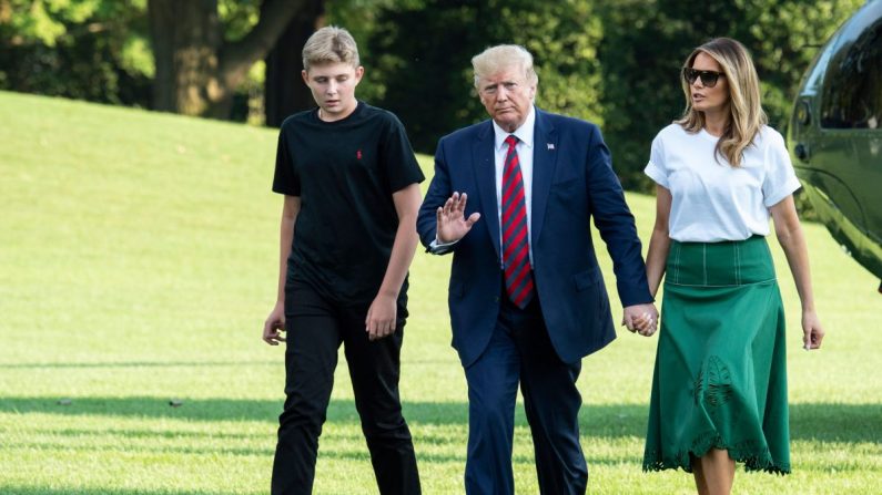 El presidente Donald Trump (en el centro), la primera dama Melania Trump (a la der.) y su hijo Barron Trump (a la izq.) regresan a la Casa Blanca después de dos semanas en el club de golf de Trump en Nueva Jersey el 18 de agosto de 2019. (Eric Baradat/AFP/Getty Images)