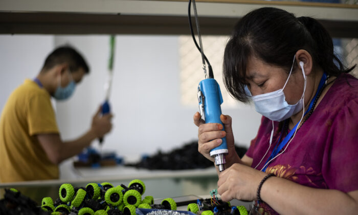Trabajadores ensamblan juguetes en la fábrica de juguetes Mendiss en Shantou, provincia de Guangdong, el 20 de mayo de 2020. Los envíos cancelados, las mercancías devueltas y la escasez de nuevos pedidos han dejado a los exportadores chinos en crisis, ya que el virus del PCCh afecta a sus socios comerciales en todo el mundo. (Noel Celis/AFP vía Getty Images)