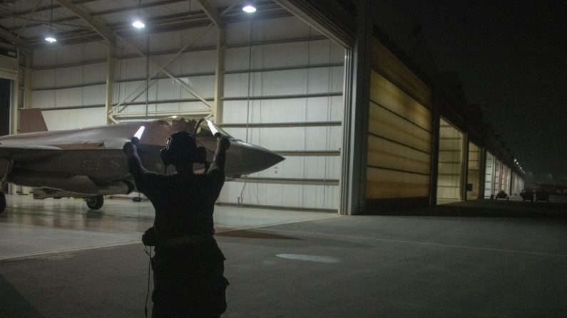 La capitana de la Fuerza Aérea de EE.UU., Emily Thompson,  saca del hangar un F-35A Lightning II mientras el aviador de primera clase, Ashlin Randolph, da la señal para que avance, en la Base Aérea de Al Dhafra, en los Emiratos Árabes Unidos. (Sargento Técnico Kat Justen/Fuerza Aérea de los Estados Unidos)