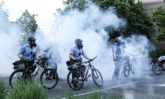 Agentes de policía despliegan gas lacrimógeno y gas pimienta para acorralar a los manifestantes antes de detenerlos durante la sexta noche de protestas y violencia tras la muerte de George Floyd, en Minneapolis, Minnesota, el 31 de mayo de 2020. (Charlotte Cuthbertson/The Epoch Times)