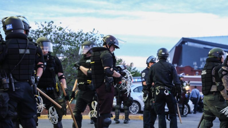 La policía estatal y local se prepara para arrestar a unos 100 manifestantes después de que se mantuvieran fuera luego del toque de queda del gobernador a las 8 p.m. durante la sexta noche de protestas y violencia tras la muerte de George Floyd, en Minneapolis, Minnesota, el 31 de mayo de 2020. (Charlotte Cuthbertson/The Epoch Times)