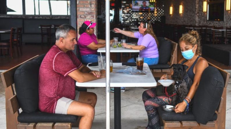 La gente come sentada afuera de un restaurante en Fort Lauderdale Beach Boulevard en Fort Lauderdale, Florida, el 18 de mayo de 2020. (Chandan Khanna/AFP a través de Getty Images)