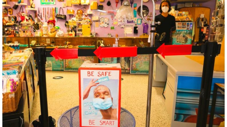 Un cartel con una mascarilla promueve las medidas de seguridad de COVID-19 en una tienda en Miami Beach, Florida el 16 de junio de 2020. (Eva Marie Uzcategui/AFP vía Getty Images)