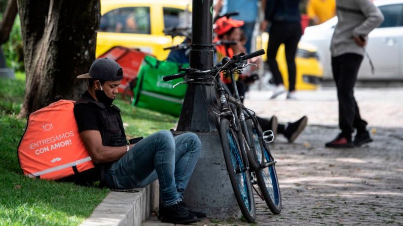 Los repartidores en bicicleta se sientan en un parque de Bogotá (Colombia) el 30 de junio de 2020. (Foto de JUAN BARRETO/AFP vía Getty Images)
