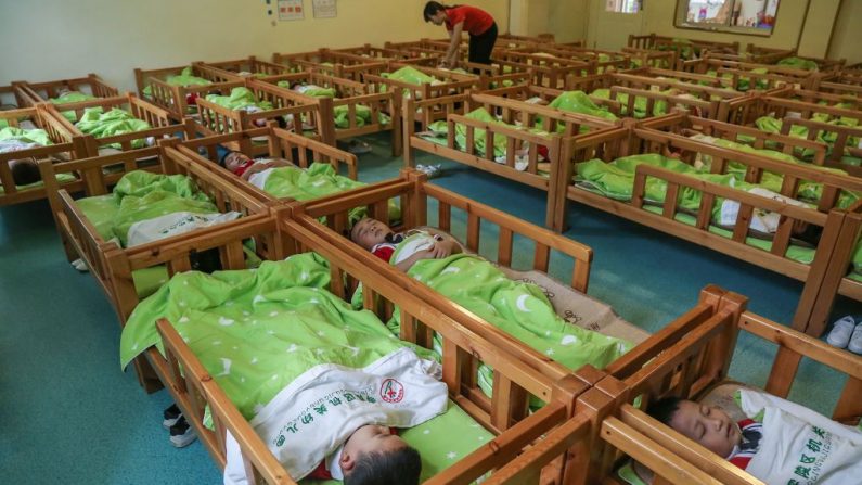 Esta foto tomada el 11 de mayo de 2020 muestra a los niños durmiendo después del almuerzo en un jardín infantil en Yongzhou, en la provincia central de Hunan, China. (STR/AFP vía Getty Images)