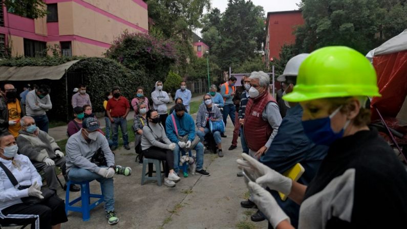 Las personas cuyos apartamentos fueron afectados por un terremoto, hablan con los ingenieros de Protección Civil después de pasar la noche en hoteles, en la Ciudad de México (México) el 24 de junio de 2020, en medio de la nueva pandemia del COVID-19. (Foto de PEDRO PARDO/AFP vía Getty Images)