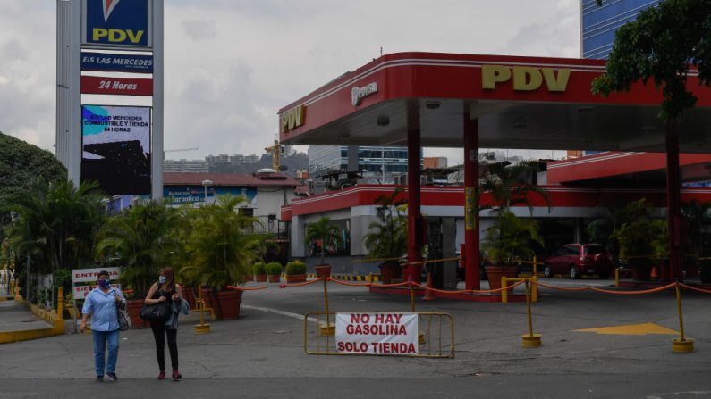 La gente pasa por delante de una gasolinera con un cartel que dice "No hay gasolina". Sólo tienda" debido a la falta de petróleo en Caracas (Venezuela), el 14 de mayo de 2020. (Federico Parra/AFP vía Getty Images)