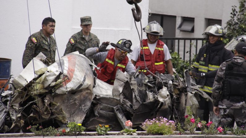 Los bomberos retiran los restos de un avión que se estrelló contra un edificio incendiándolo en un barrio residencial del norte de Quito (Ecuador) el 20 de marzo de 2009. (PABLO COZZAGLIO/AFP a través de Getty Images)