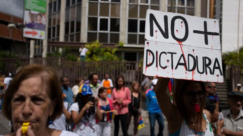 Una mujer sostiene una pancarta que dice "No más dictadura" durante una manifestación contra el régimen de Nicolás Maduro convocada por Juan Guaidó el 30 de enero de 2019 en Caracas, Venezuela.(Marco Bello/Getty Images)