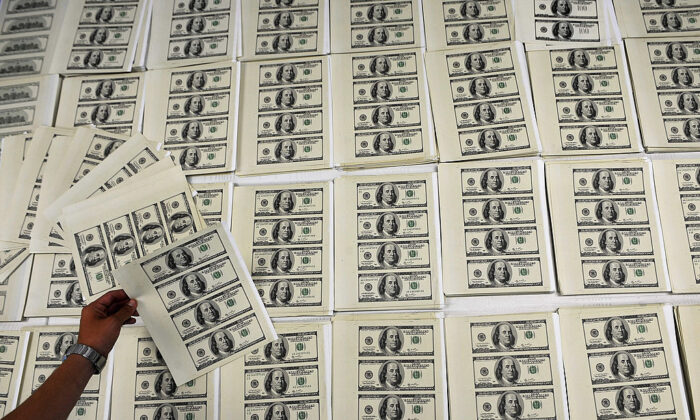 Un oficial de policía colombiano sostiene un billete de 100 dólares estadounidenses falsificado, en Cali, Colombia, el 22 de marzo de 2011. Imagen de archivo. (Luis Robayo/AFP vía Getty Images)