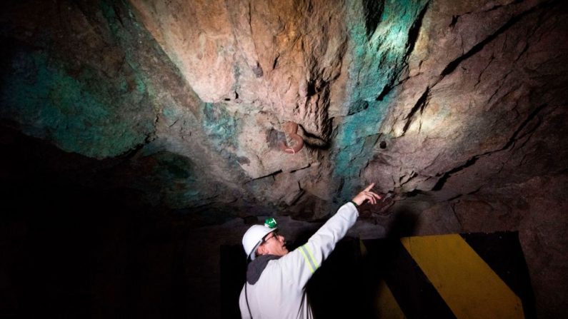 El geólogo de la mina señala dónde está el arrecife de monazita (roca más oscura) que contiene los minerales de tierras raras, bajo tierra en la mina de tierras raras SKK el 29 de julio de 2019, a unos 80 km de la ciudad de Vanrhynsdorp, en el Cabo Occidental. (RODGER BOSCH AFP a través de Getty Images)