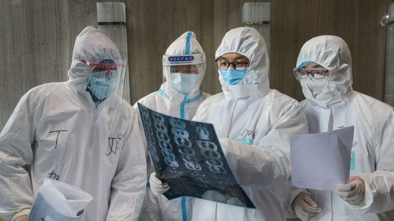 Esta foto tomada el 20 de febrero de 2020 muestra a los médicos mirando una imagen de una tomografía computarizada de un pulmón en un hospital del condado de Yunmeng, en la ciudad de Xiaogan, en la provincia central de Hubei en China. (STR/AFP vía Getty Images)