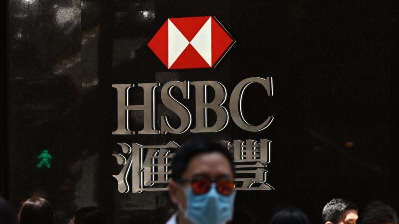 Los peatones con mascarillas mientras pasan por delante de los letreros del HSBC en el exterior de una sucursal del banco en Hong Kong el 28 de abril de 2020. (Anthony Wallace/AFP vía Getty Images)