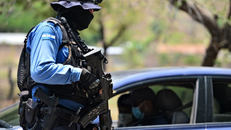 En la imagen ilustrativa, un agente de policía se prepara para revisar un vehículo procedente de Nicaragua en el punto de cruce de Guasaule, Honduras, el 13 de mayo de 2020. (Foto de ORLANDO SIERRA/AFP vía Getty Images)
