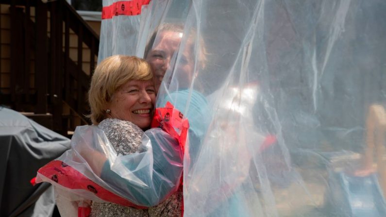 Carolyn Ellis (de) abraza a su madre Susan Watts en el Día de la Madre en Guelph, Ontario, Canadá, el 16 de mayo de 2020. (JORGE UZON/AFP vía Getty Images)