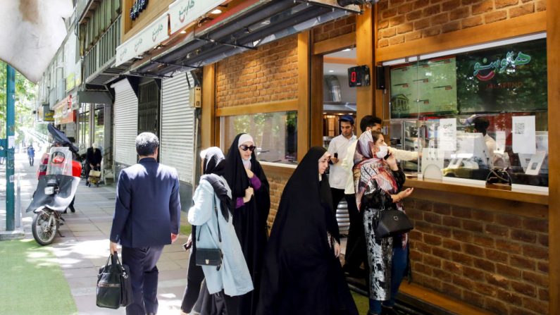 La gente espera sus pedidos en un restaurante de la capital de Teherán (Irán), el 26 de mayo de 2020. (Foto de AFP a través de Getty Images)