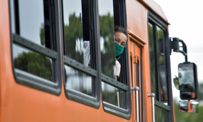 Una mujer con mascarilla se asoma por la ventana de un autobús en La Habana el 2 de junio de 2020. (Yamil Lage/AFP vía Getty Images)