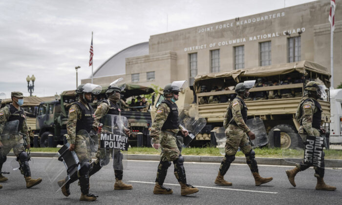 Las tropas se cargan en vehículos de transporte de personal para llevarlos hacia la ciudad desde la sede de la Fuerza Conjunta de la Guardia Nacional de DC en Washington el 2 de junio de 2020. (Drew Angerer/Getty Images)
