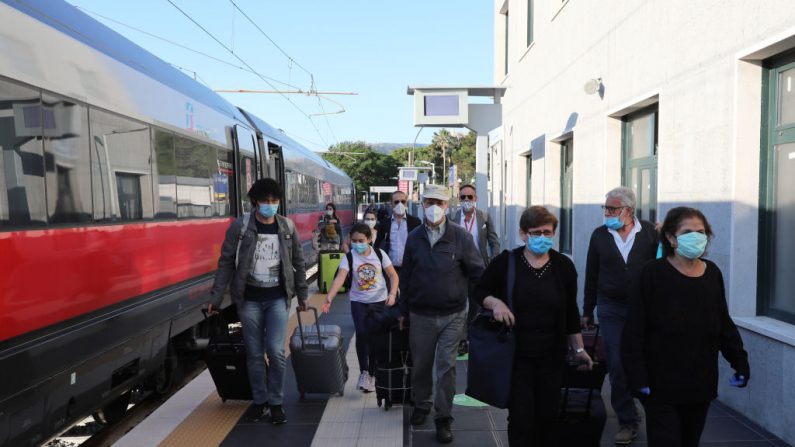 Los pasajeros se bajan del primer tren de alta velocidad Freccia Rossa de largo recorrido que conecta Turín y Reggio Calabria en la historia del sistema ferroviario italiano después de su viaje el 3 de junio de 2020 en Reggio Calabria, Italia. (Marco Di Lauro/Getty Images)