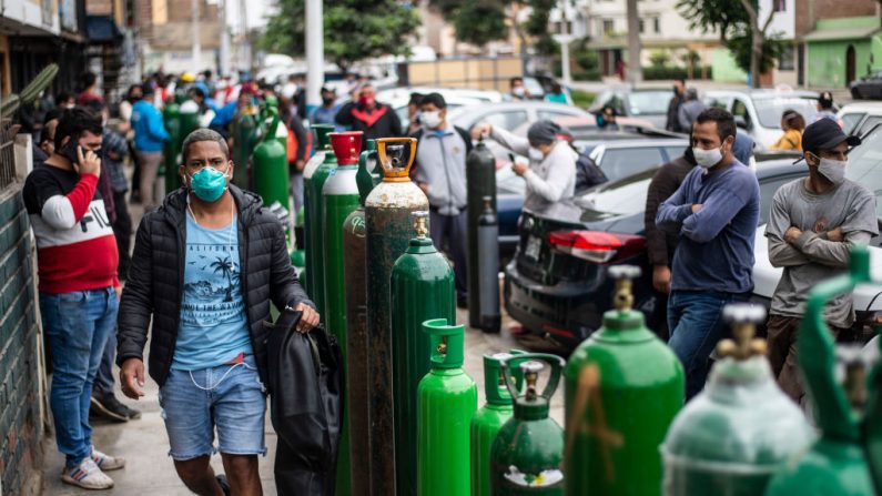 La gente hace cola para rellenar sus cilindros de oxígeno vacíos en el Callao, Perú, el 3 de junio de 2020 en medio de la pandemia del  COVID-19. (Foto de ERNESTO BENAVIDES/AFP vía Getty Images)