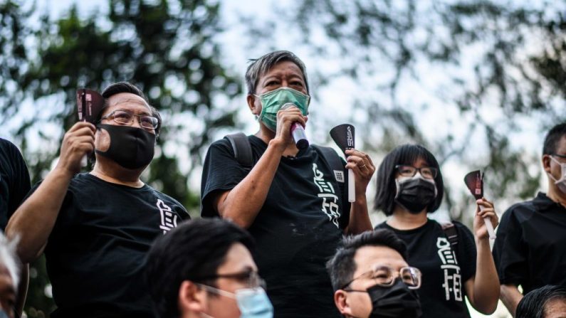 Albert Ho (arriba a la izquierda) y Lee Cheuk-yan (arriba a la derecha) de la Alianza en Apoyo de los Movimientos Patrióticos Democráticos de China, hablan mientras sostienen velas antes de entrar en el Parque Victoria en Hong Kong el 4 de junio de 2020. (Anthony Wallace/AFP vía Getty Images)