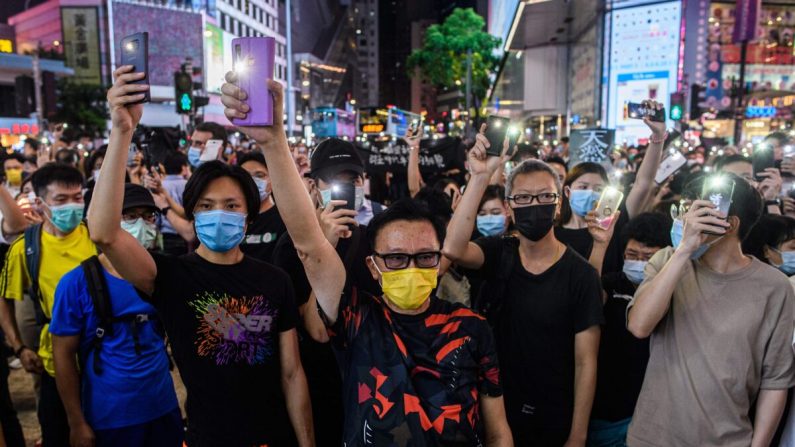 Activistas en favor de la democracia sostienen las linternas de sus celulares mientras cantan durante un mitin en el distrito de Causeway Bay de Hong Kong el 12 de junio de 2020. (Anthony Wallace/AFP a través de Getty Images)