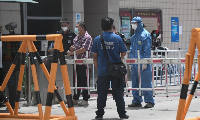 Un personal de seguridad vestido con un traje protector hace guardia en una zona residencial bajo llave cerca del Mercado Oriental de Yuquan en Beijing, China, el 15 de junio de 2020. (NOEL CELIS/AFP vía Getty Images)