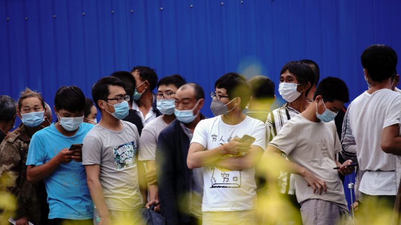 Los residentes que visitaron o viven cerca del Mercado Xinfadi de Beijing se alinean para una prueba de ácido nucleico el 19 de junio de 2020. (Lintao Zhang/Getty Images)