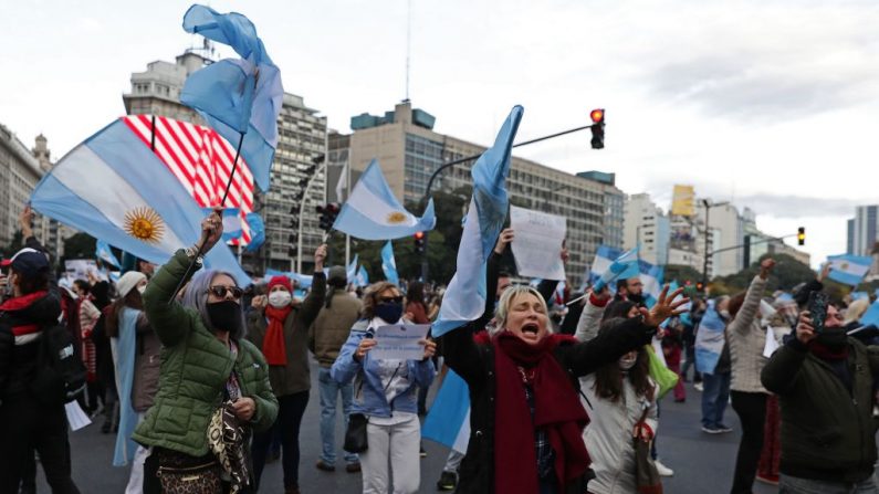 Manifestantes ondean las banderas nacionales de Argentina durante una protesta contra la cuarentena y la expropiación de la empresa agroindustrial Vicentín por parte del Gobierno del presidente Alberto Fernández en el Obelisco de Buenos Aires, el 20 de junio de 2020. (Foto de ALEJANDRO PAGNI/AFP vía Getty Images)