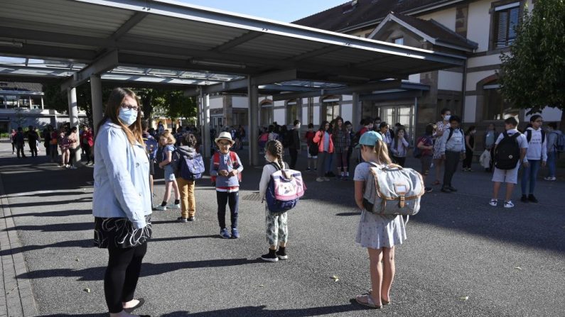 Los niños hacen cola para entrar en sus aulas en la escuela primaria Ziegelau de Estrasburgo, en el este de Francia, ya que las escuelas primarias y secundarias se reabren en Francia el 22 de junio de 2020. (Foto de FREDERICK FLORIN/AFP vía Getty Images)