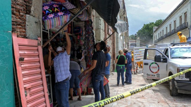 Vecinos toman precauciones por un edificio dañado durante un terremoto en Oaxaca, México, el 23 de junio de 2020. (PATRICIA CASTELLANOS/AFP vía Getty Images)