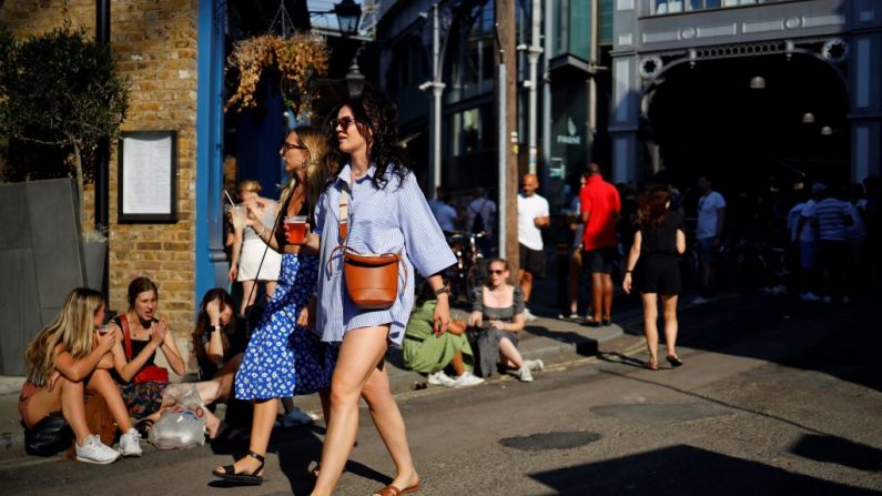 La gente se relaja con cerveza de barril para llevar en vasos de plástico al final del día, en el mercado de Borouhg en Londres (Reino Unido) el 26 de junio de 2020. (Foto de TOLGA AKMEN/AFP vía Getty Images)