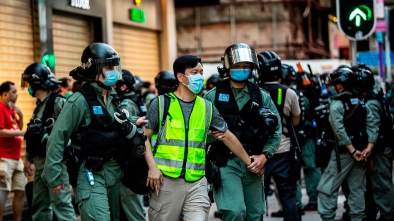 La policía arresta a un hombre (C) y lo lleva a un autobús cercano durante una protesta contra la ley de seguridad nacional de China planeada en Hong Kong el 28 de junio de 2020. (Issac Lawrence/AFP vía Getty Images)
